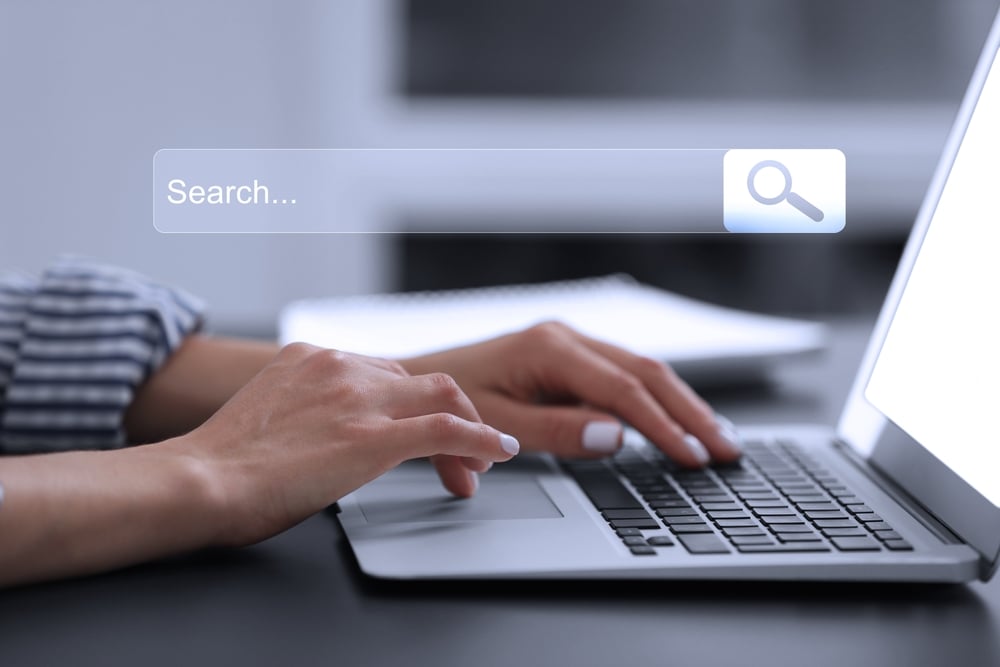 Person typing a search query into a laptop